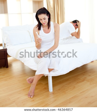 Cheerless couple finding out results of a pregnancy test in the bedroom