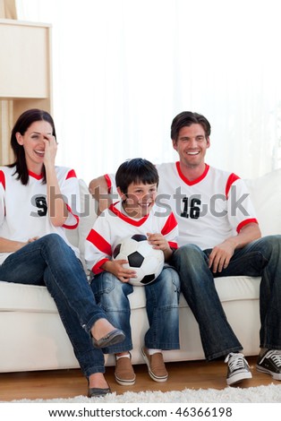 Positive family watching football match on television