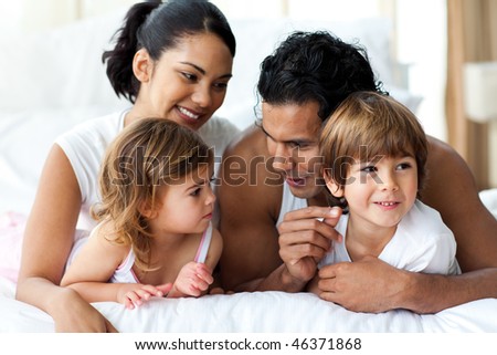 Animated family having fun lying on bed at home