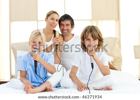 Jolly family singing together through microphones