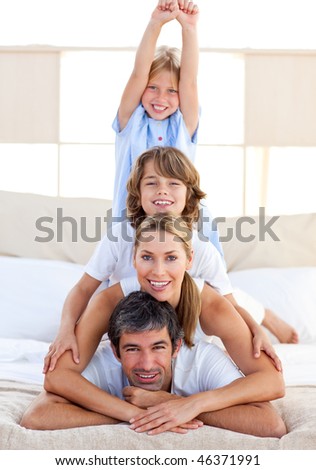 Jolly family having fun in the bedroom