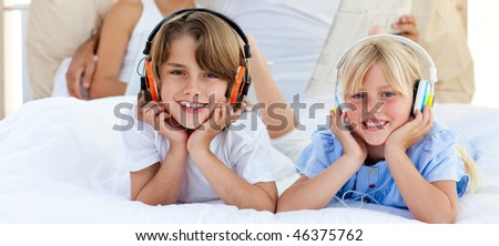 Animated siblings listening music with headphones lying on bed