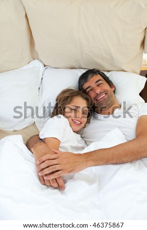 Attractive father hugging his son lying in the bed