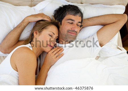 Positive couple sleeping lying in bed