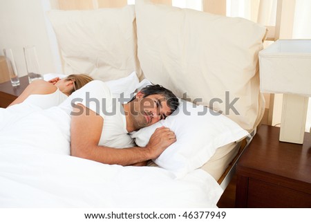 Sad couple lying in the bed after having an argument
