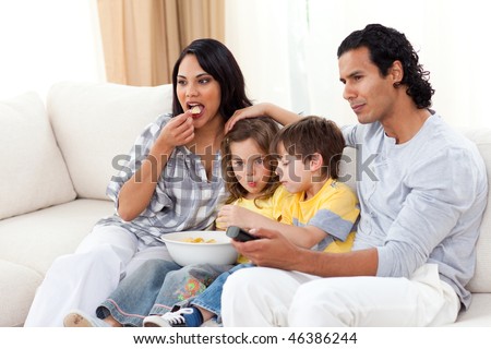 Lively family watching TV on sofa in the living room