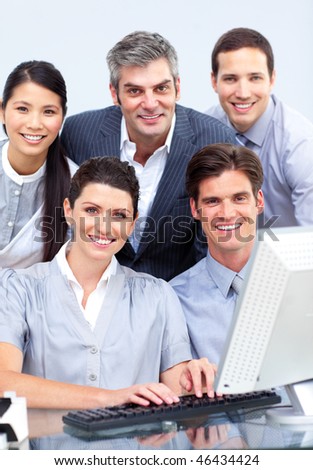 Cheerful business group working at a computer in a company
