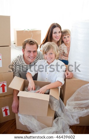 Happy family packing boxes while moving house