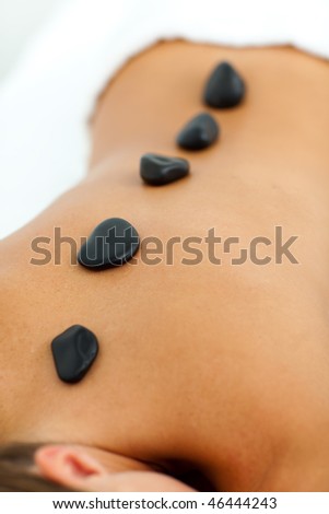 Relaxed woman getting spa treatment with stones