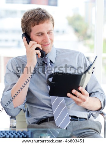 Serious businessman planning an appointment on phone in the office