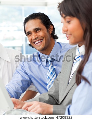 Laughing businessman working with his team in the office