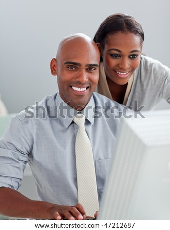 Charming businesswoman helping her colleague at a computer in the office