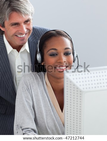 Smiling manager checking his employee's work in the office