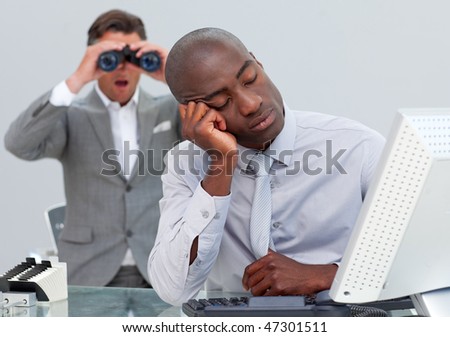 Asleep businessman annoyed by a man looking through binoculars in the office