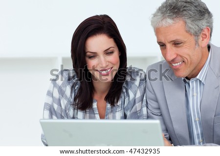 Smiling business partners working at a computer in an office