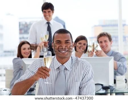 Lucky business team drinking champagne in the office