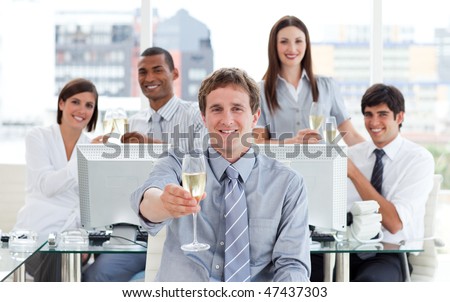 Fortunate business team drinking champagne in the office