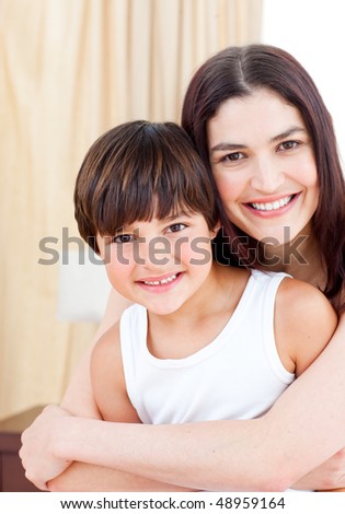 Smiling mother hugging her son at home