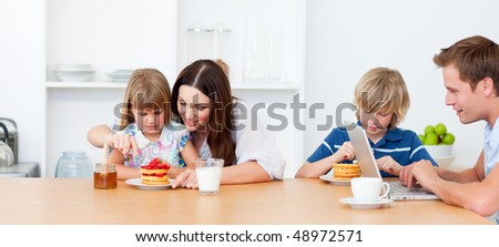 Happy family eating breakfast in the kitchen at home