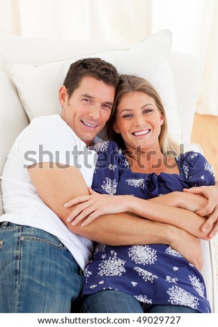 Affectionate couple lying down on sofa  at home