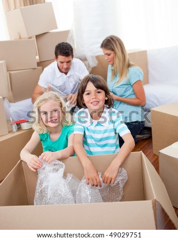 Lively family packing boxes while moving house