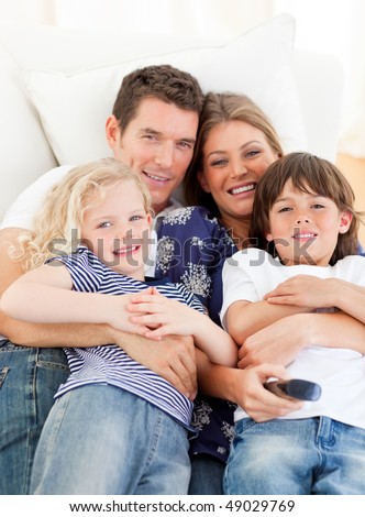 Caucasian family watching television sitting on sofa at home