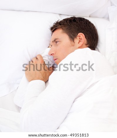 Portrait of a sad man lying in bed at home