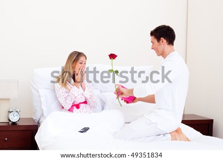 Affectionate husband giving a present to his wife in the bedroom