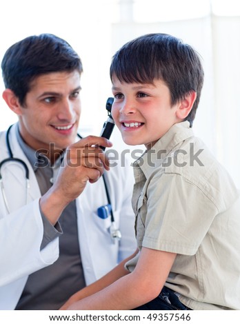 Handsome doctor examining little boy\'s ears at the practice