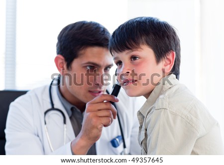 Young doctor examining little boy\'s ears at the practice