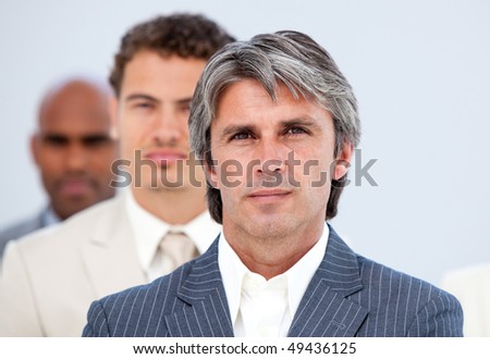Self-assured manager and his team looking at the camera in a company