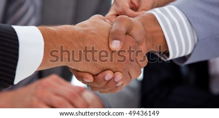 Close-up of business people closing a deal in a meeting