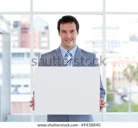 Portrait of a male manager holding a white board in the office
