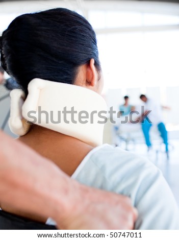 Close-up of a woman with a neck brace sitting on wheelchair in hospital