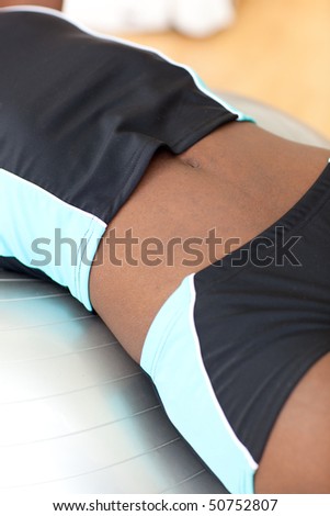 Close-up of a woman doing sit-ups with a Pilate ball at home