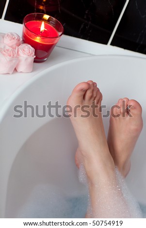 Young woman\'s feet in a bath in a spa center