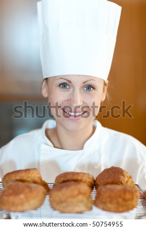 Smiling female chef baking scones in the kitchen