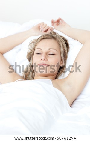 Relaxed woman sleeping on a bed against a white background