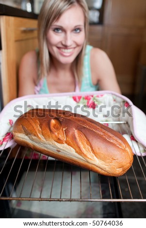 Happy woman baking bread in the kitchen