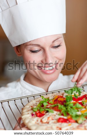 Smiling female chef preparing a pizza