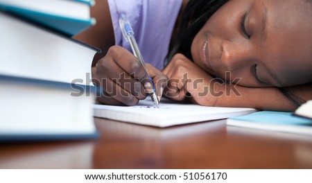 Close-up of a tired afro-american teen girl studying in a library