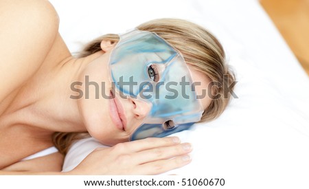 Peaceful woman with an eye gel mask against a white background