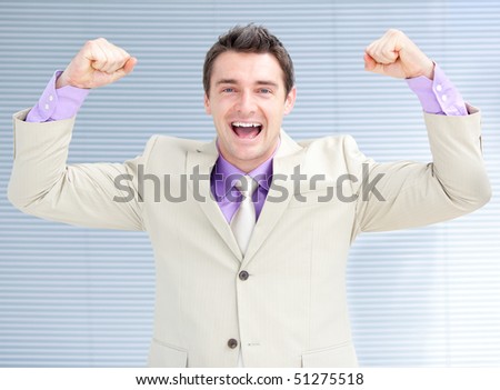Jolly businessman punching the air in celebration