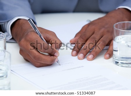 Close-up of ambitious business man signing a contract in a company