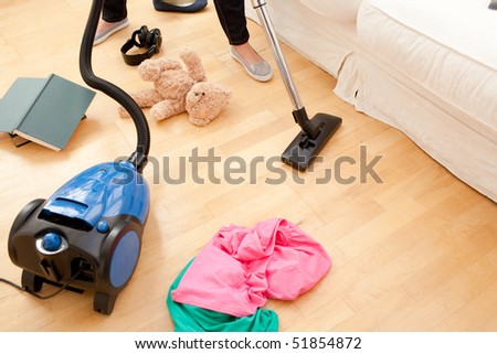 Close-up of a woman vacuuming the living-room