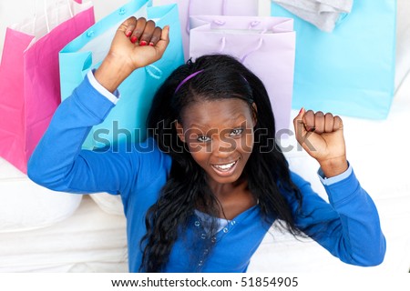 Cheerful Afro-American woman punching the air in celebration after shopping