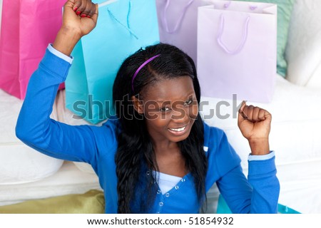 Joyful Afro-American woman punching the air in celebration after shopping