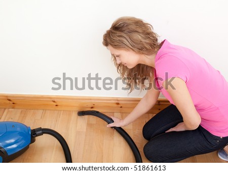 Portrait of a charming woman vacuuming at home