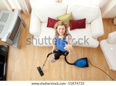 High angle of a cheerful woman vacuuming in the living-room