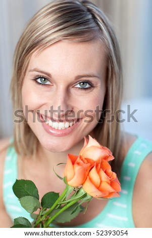 Portrait of a radiant woman holding roses at home